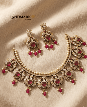 Landmark Jewels imitation necklace set featuring heart-shaped ruby stones, pearl drops, and gold-toned peacock motifs with matching earrings.
