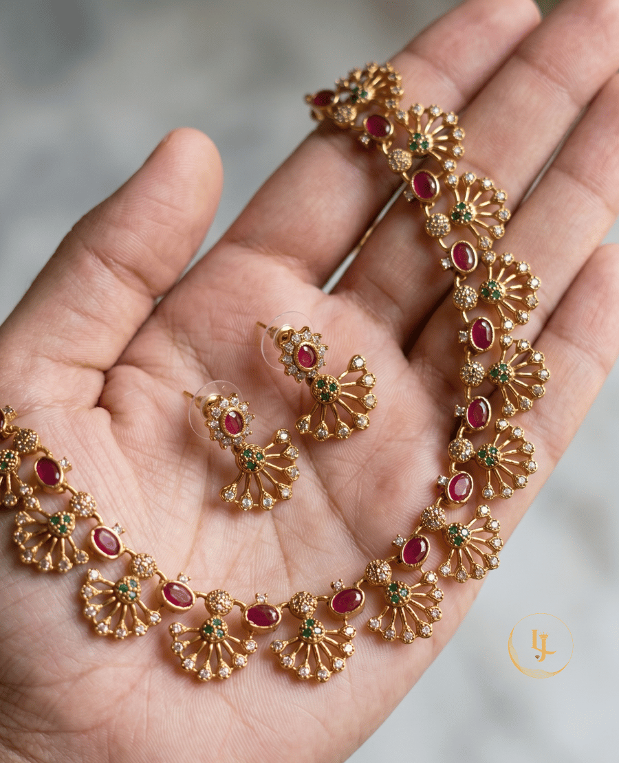 handheld-view-showing-the-detailed-craftsmanship-and-scale-of-the-matte-gold-fan-style-necklace-and-matching-earrings