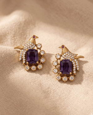 Landmark Jewels gold-plated bird motif stud earrings featuring an emerald-cut purple center gemstone and sparkling cubic zirconia crystal accents.