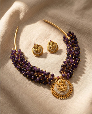 Antique gold temple hasli necklace with purple beads, Lakshmi pendant and matching stud earrings