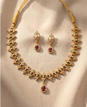 Minimal gold plated floral choker necklace set with ruby red drop and American diamonds