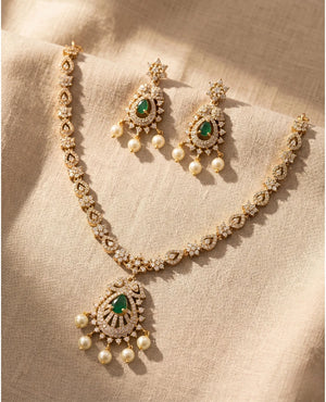 Gold plated emerald green American diamond temple necklace set with pearl drop pendant and earrings