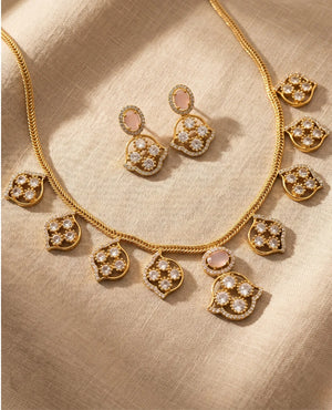 Blush pink CZ gold plated mango paisley necklace set with matching earrings on fabric