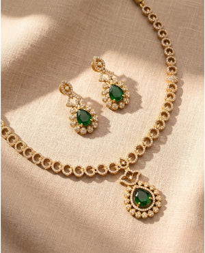Gold plated CZ necklace with emerald green teardrop pendant and matching green stone earrings