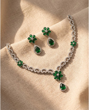 Silver rhodium plated American diamond necklace set with emerald green floral design and matching earrings