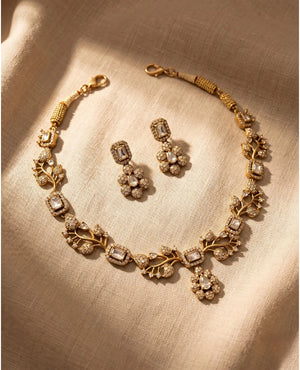 Matte gold floral vine necklace with white American diamond stones and matching drop earrings