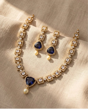 Antique gold necklace set with royal blue triangular stone, CZ diamonds and pearl drop