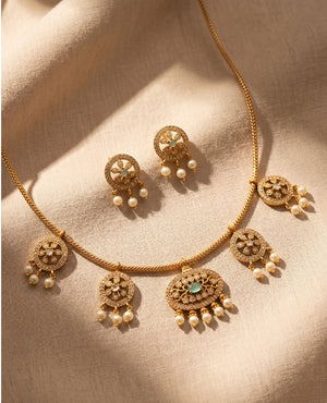 Delicate gold plated American diamond station necklace with pearl drops and mint green stone earrings