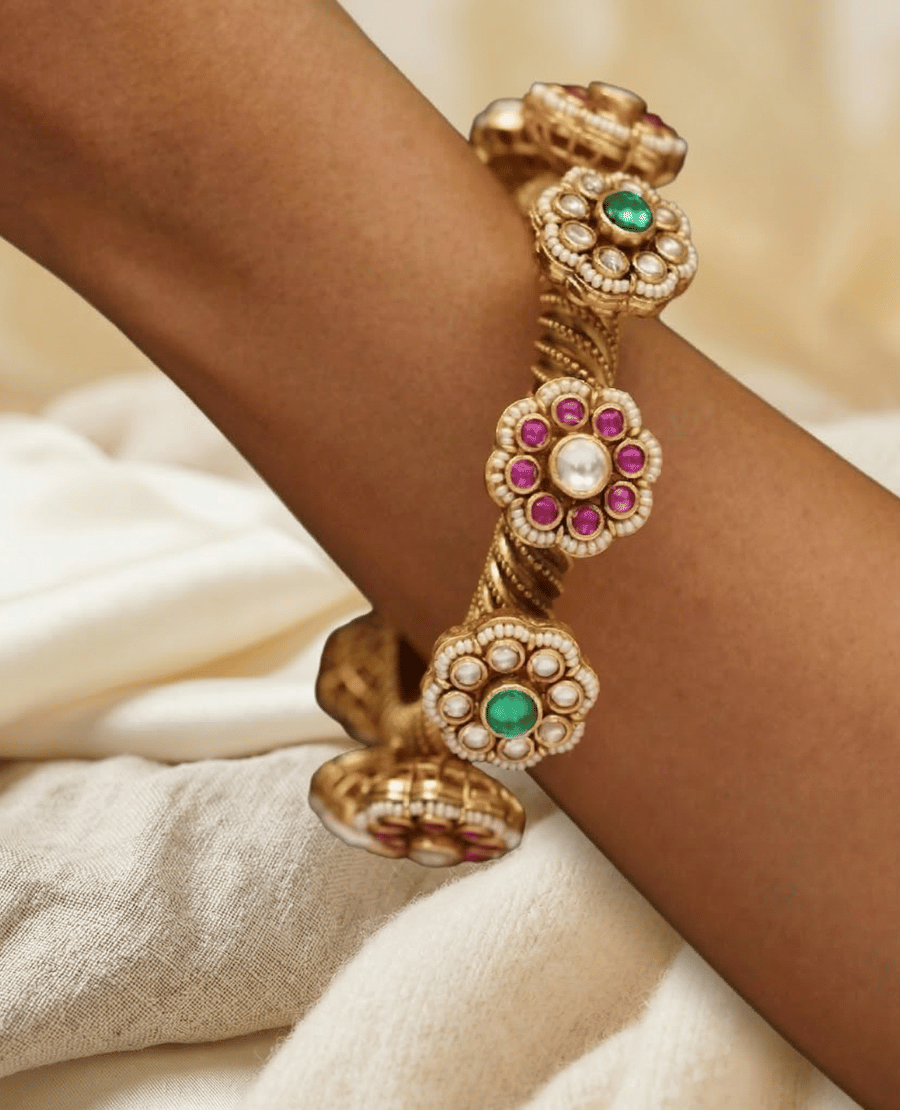 traditional-gold-kada-bangle-with-intricate-filigree-work-and-embedded-green-emeralds-for-weddings