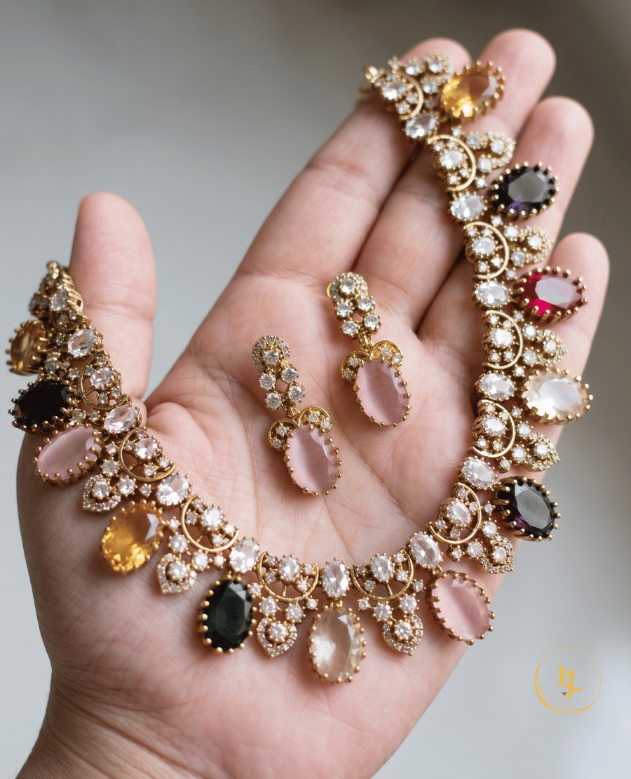 a-person-holding-the-landmark-jewels-colorful-gemstone-necklace-and-earrings-to-show-scale-and-the-intricate-cz-diamond-like-detailing